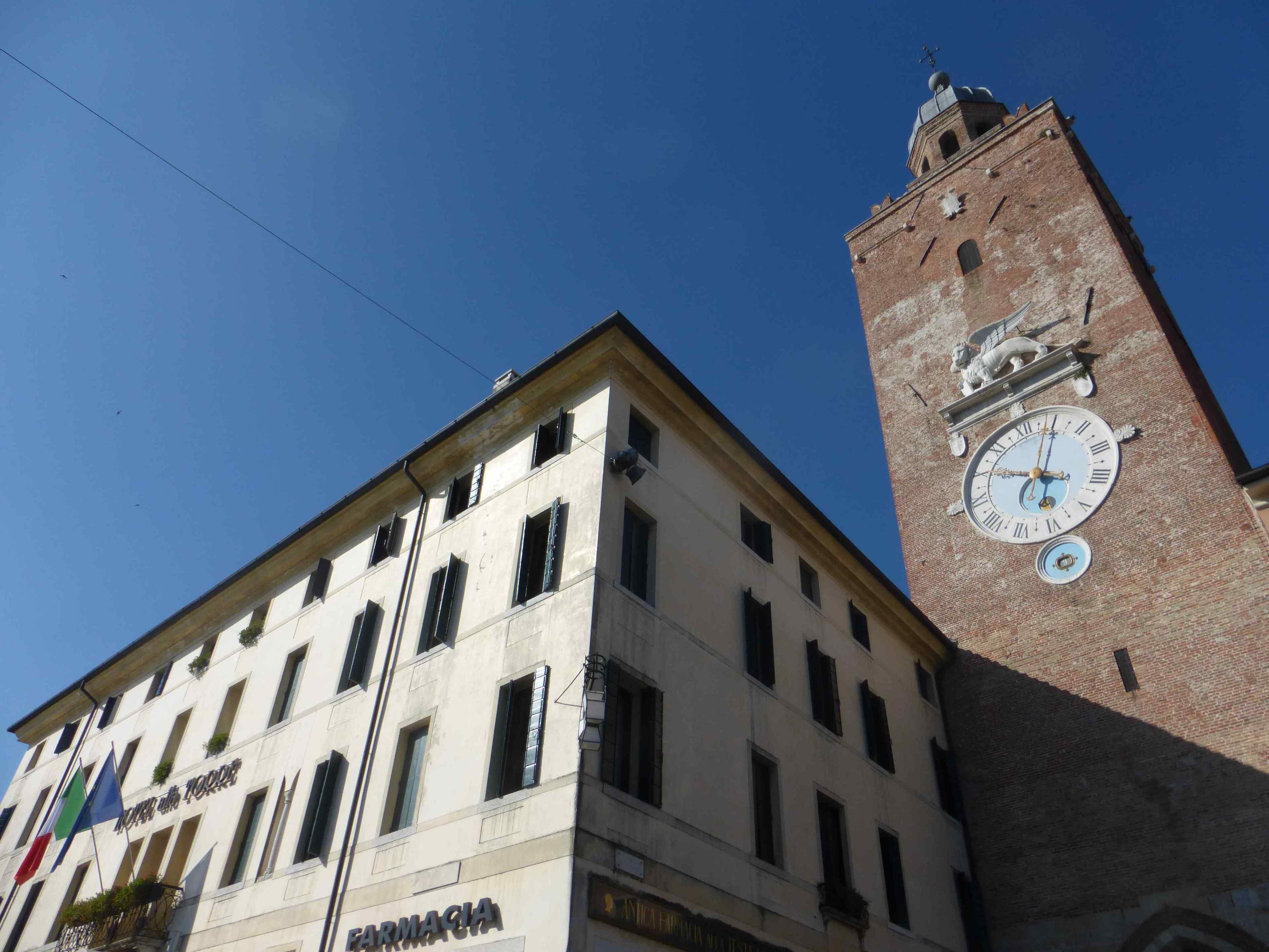 A building with a clock tower and a pharmacy sign.