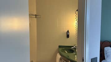 Ein Badezimmer mit einem grünen Waschbecken, einem Bidet und einer weißen Toilette.