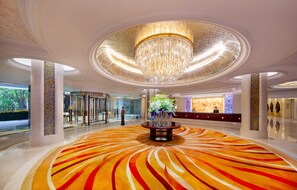 A spacious lobby with a large, ornate chandelier, a reception desk, and a vibrant carpet design. - Shangri-La Suzhou (Suzhou)