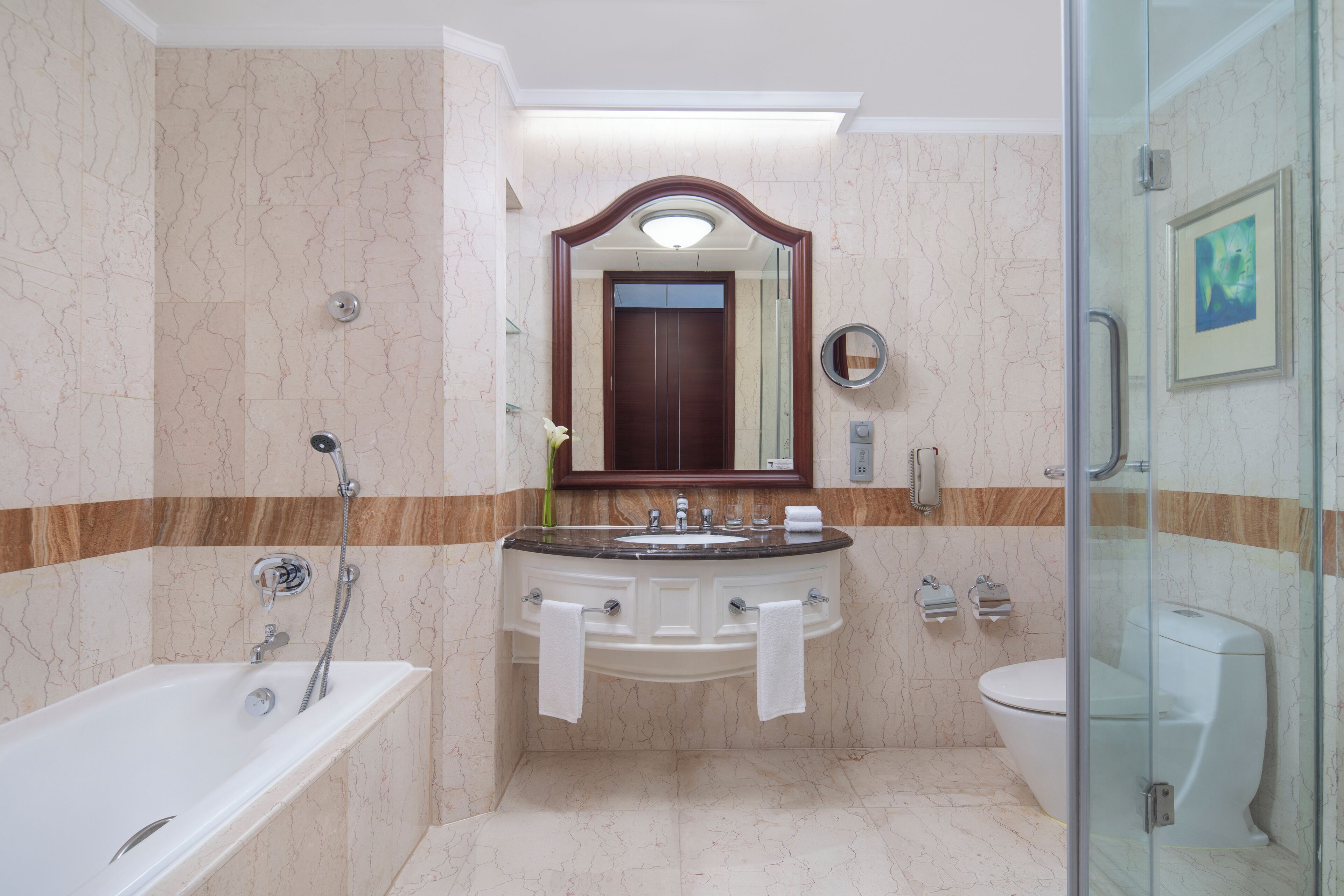 Ein Badezimmer mit einer Badewanne, einem Waschbecken mit zwei Spiegeln und einer Toilette.