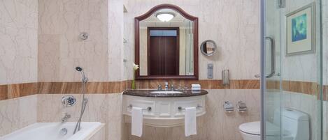 A bathroom with a bathtub, a sink with two mirrors, and a toilet.
