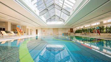 Swimmers can enjoy a spacious pool area with lane markers, lounge chairs, and a seating area.