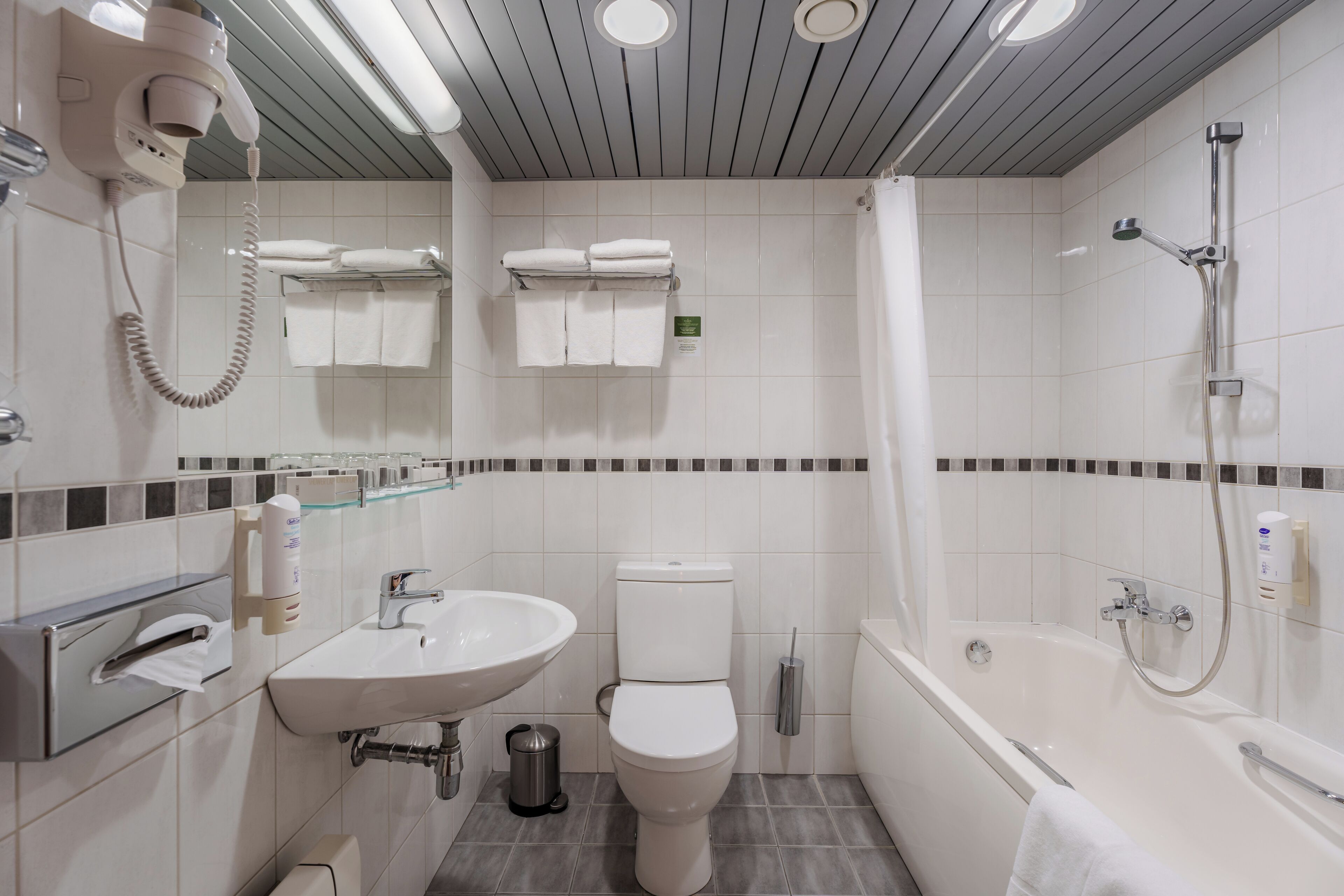 A modern bathroom with a toilet, sink, and bathtub.