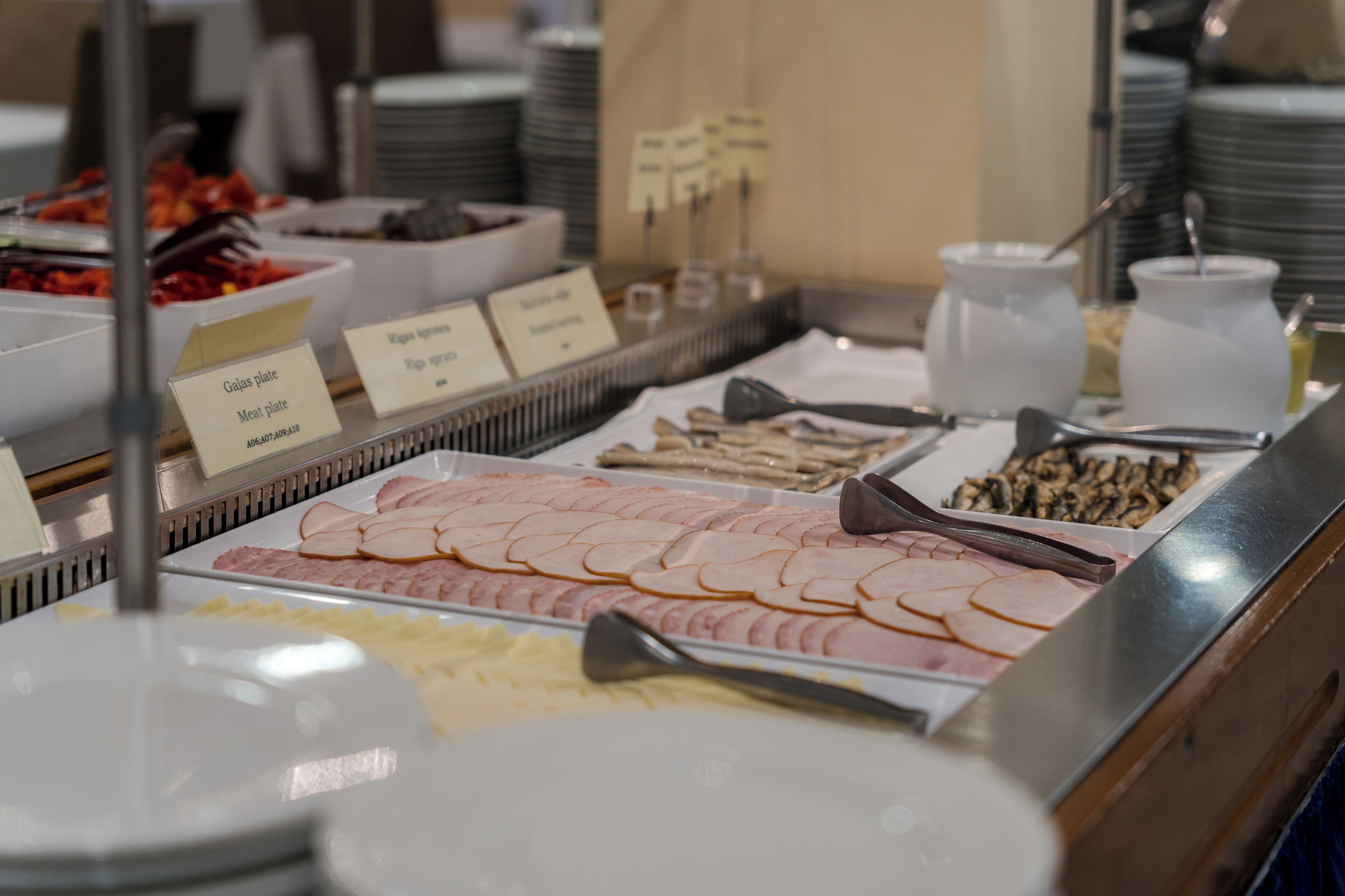 A buffet with various food items including meats, cheeses, and fruits.