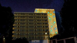 A multi-story hotel with balconies and a starry night sky. - Hotel Gala Placidia (Benidorm)