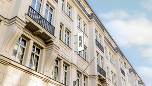 A multi-story building with a classic architectural style, featuring balconies and large windows. - Garner Hotel Berlin - Checkpoint Charlie by IHG (Berlin)