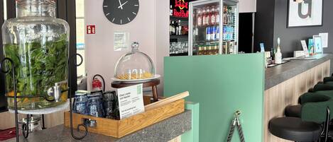 A bar area with a large jar of green herbs, a clock, and a Red Bull sign in the background.