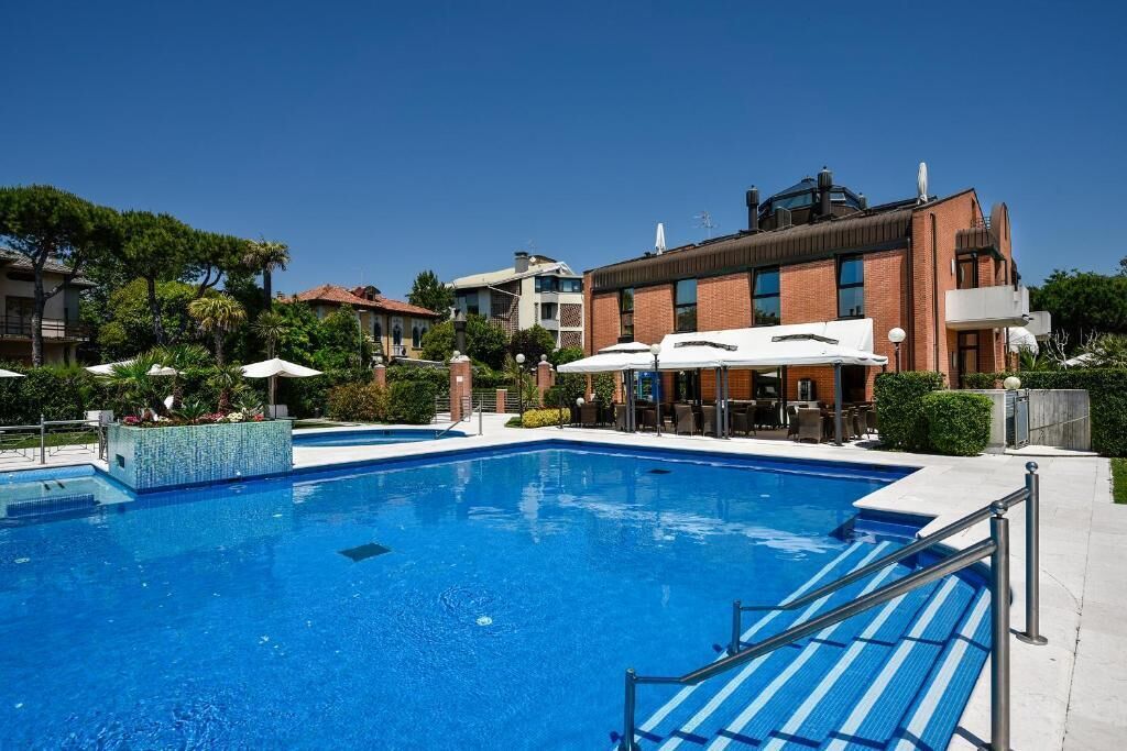 Una piscina al aire libre de temporada, sombrillas