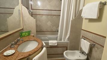 Un baño con lavamanos, inodoro y bañera.
