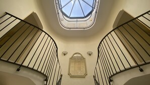 Una escalera en espiral con tragaluces en la parte superior, que conduce a un piso superior.