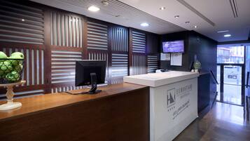 Una recepción de hotel de diseño moderno, una pantalla de televisión y una pantalla digital.