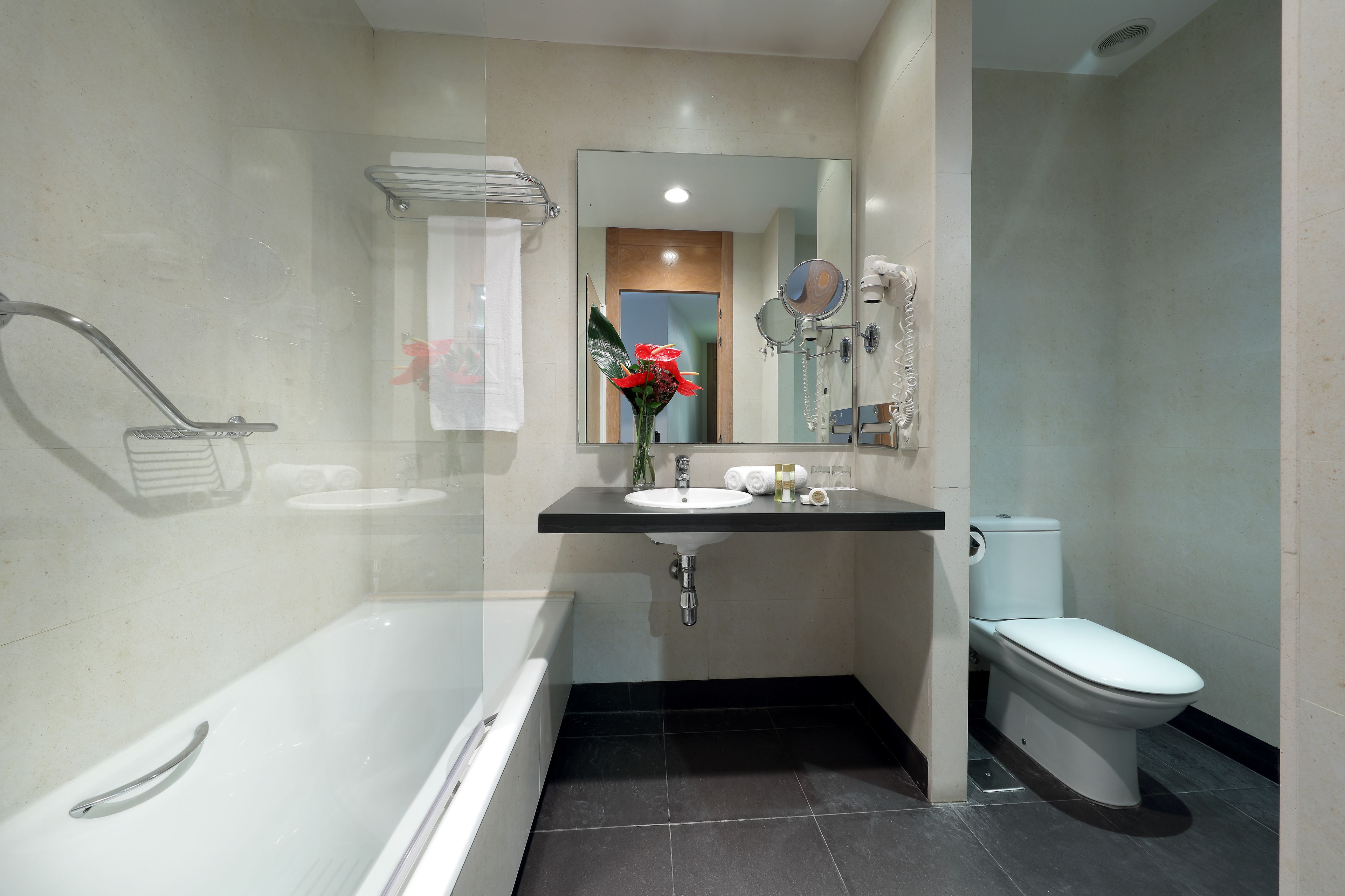 A modern bathroom with a bathtub, sink, and toilet.
