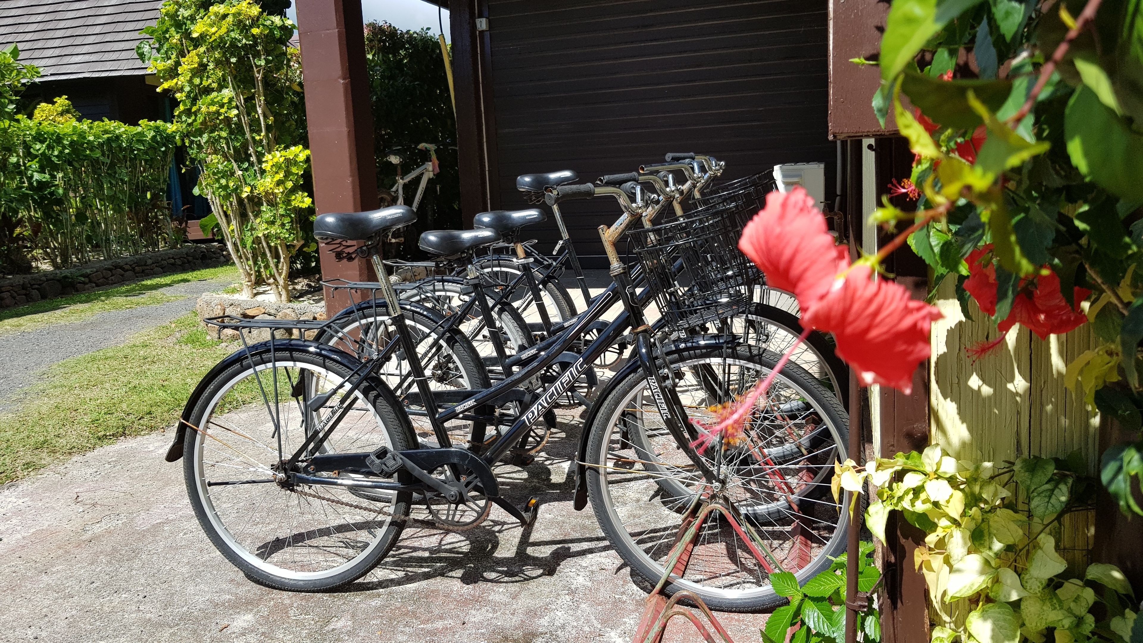 Flere cykler parkeret uden for en bygning med en garageport.