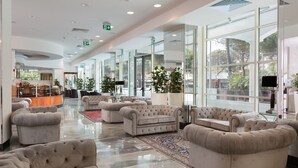 A spacious lobby with multiple seating areas, large windows, and a central bar area. - Hotel Continental Rimini (Rimini)
