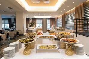 Disposició de bufet amb diversos plats, un pilaret central i un disseny interior modern.