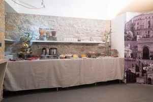 Una mesa con una variedad de alimentos y condimentos, dispuesta en un buffet, con un fondo de pared de piedra.
