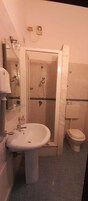 Un baño con lavamanos, inodoro y cabina de ducha.