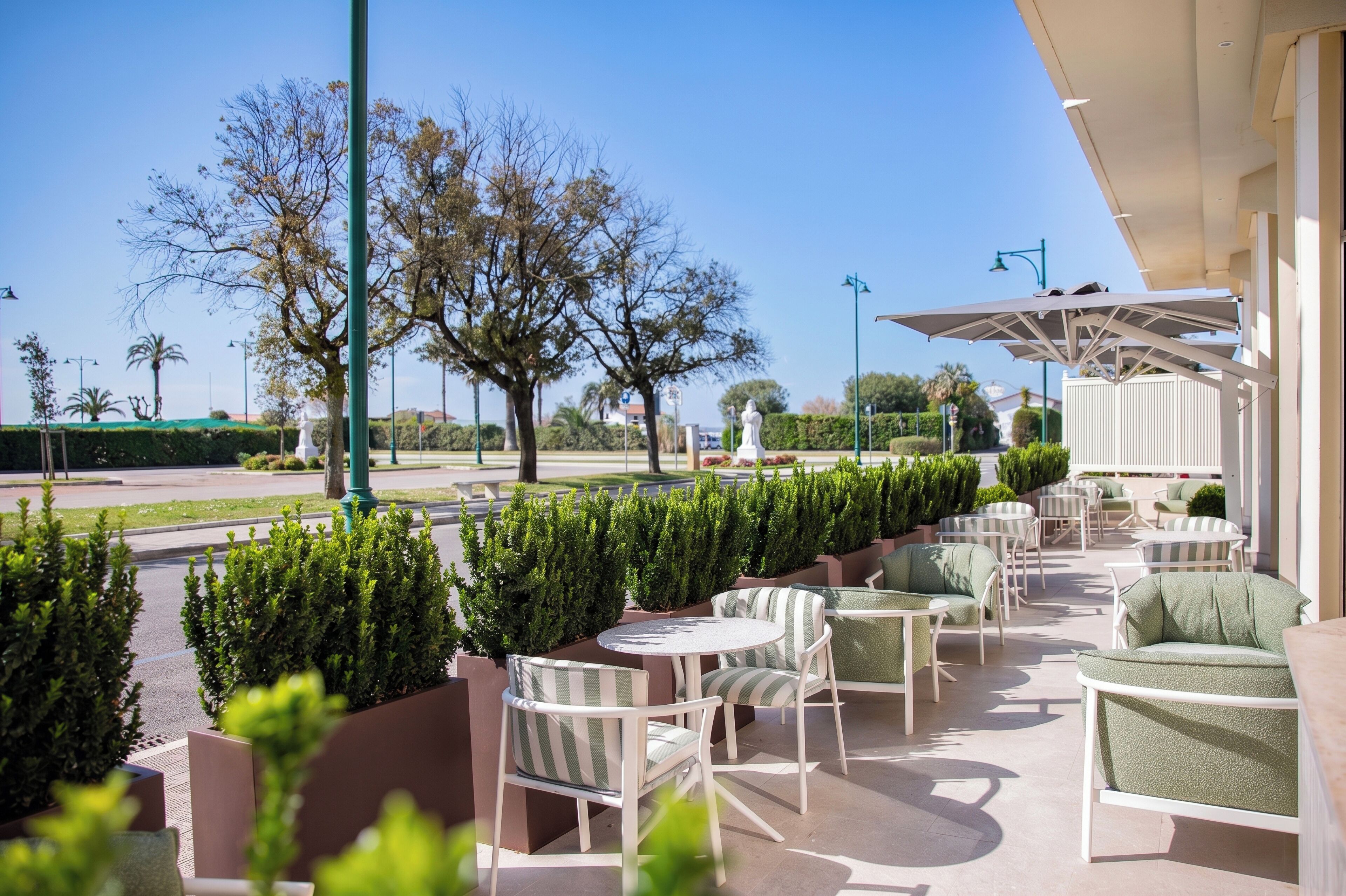 An outdoor patio area with seating, a statue, and a view of the street.