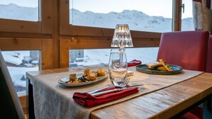 Una mesa de madera con un vaso de agua, un paño de papel rojo y platos de comida.