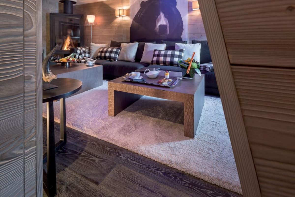 A cozy living area with a sofa set, a coffee table, and a fireplace.