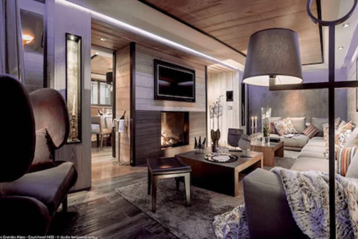 A modern living room with a fireplace, a television, and a cozy seating area.