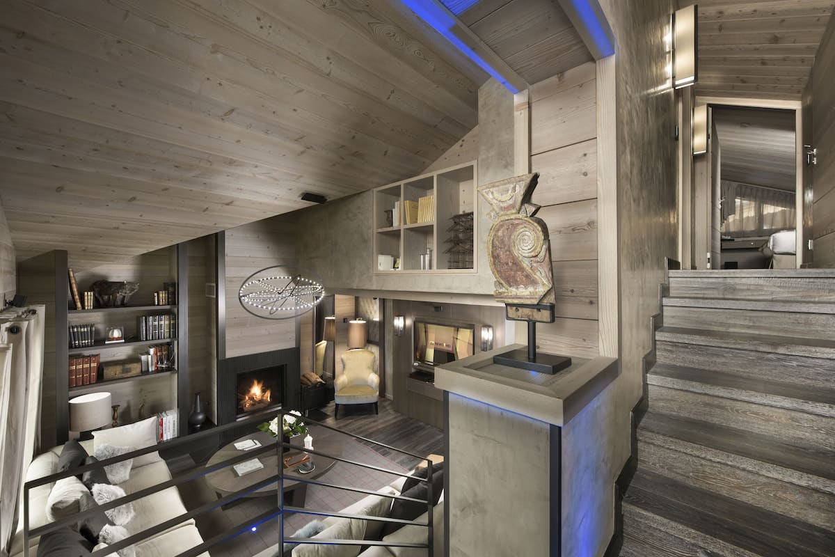 A modern interior with a fireplace, bookshelves, and a seating area.