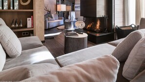 A modern living room with a fireplace, wooden beams, and a cozy seating area.