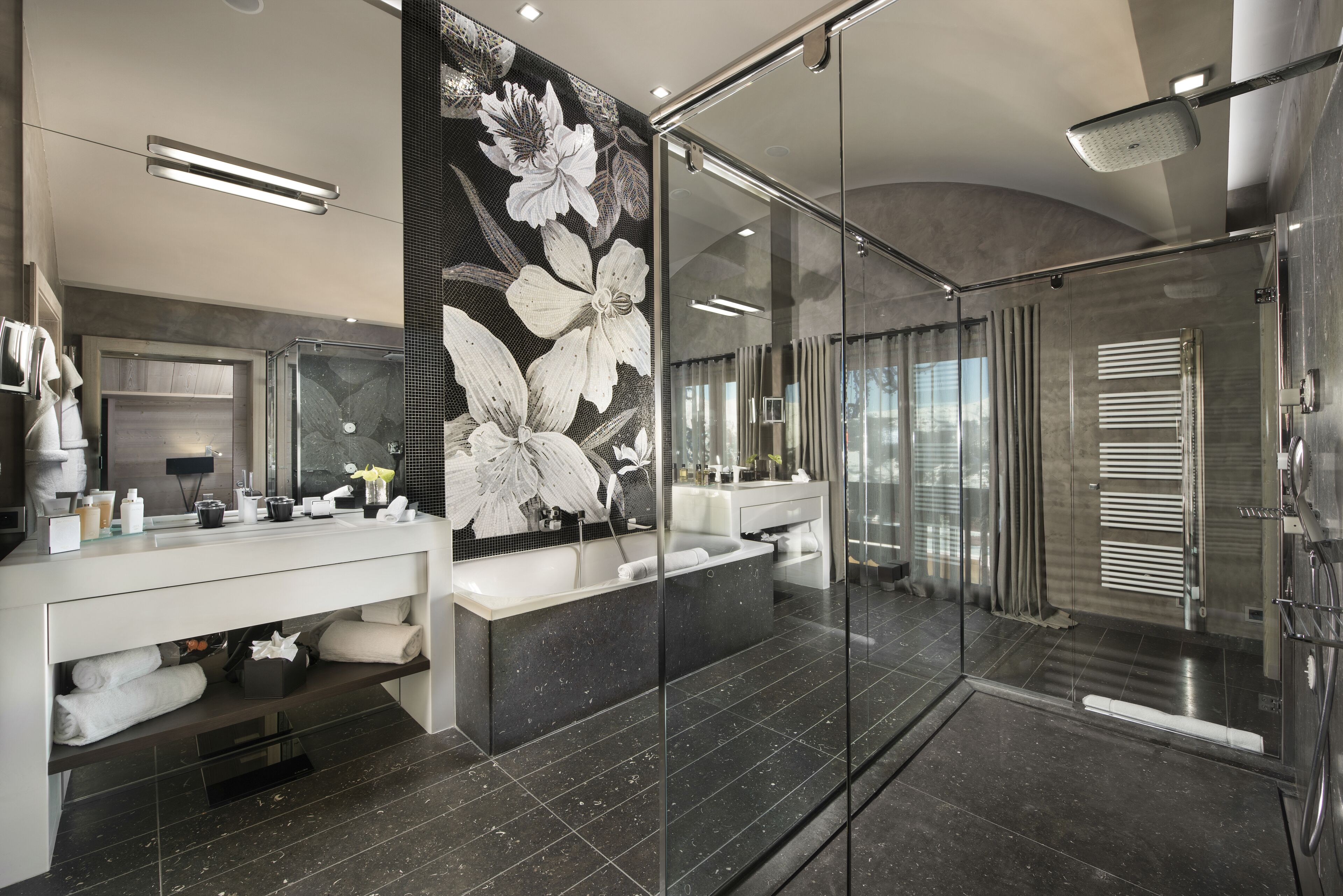 Un baño moderno con cabina de ducha de vidrio, un espejo grande y un panel decorativo en la pared.