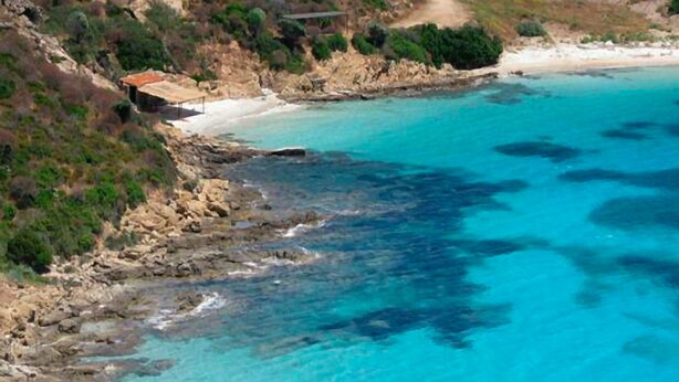 A coastal landscape with a rocky shoreline, a sandy beach, and a clear blue sea. - Ariadimari Hotel (Valledoria)