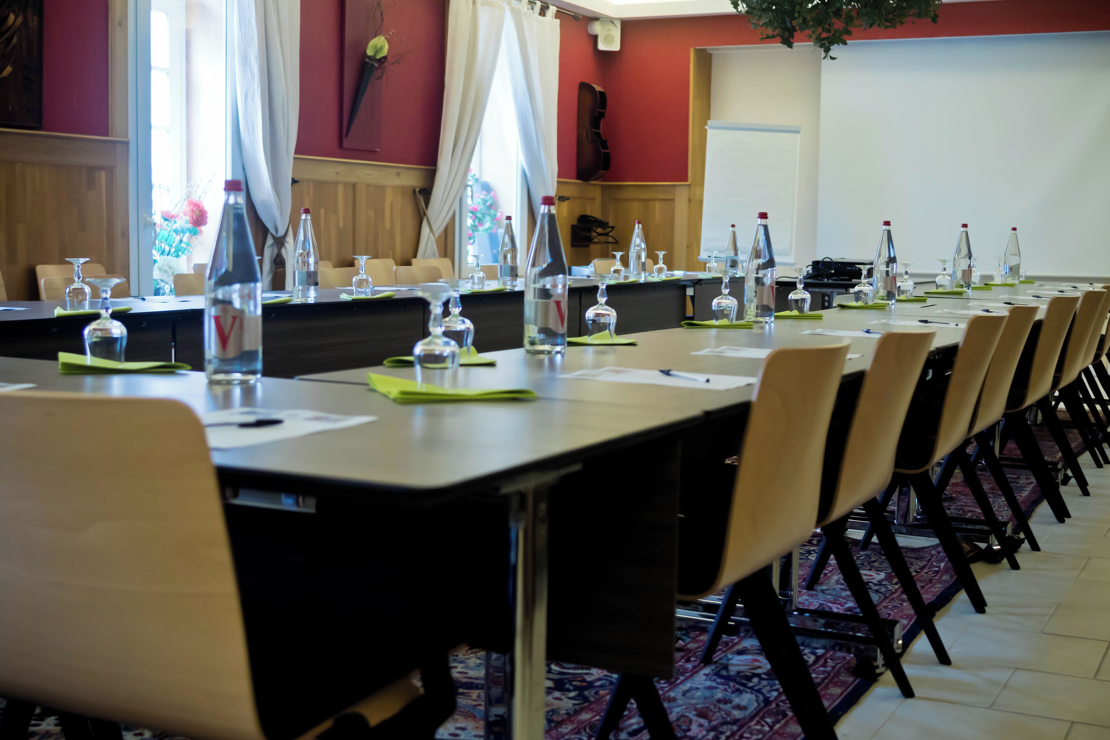 A conference room with long tables, chairs, and water bottles.