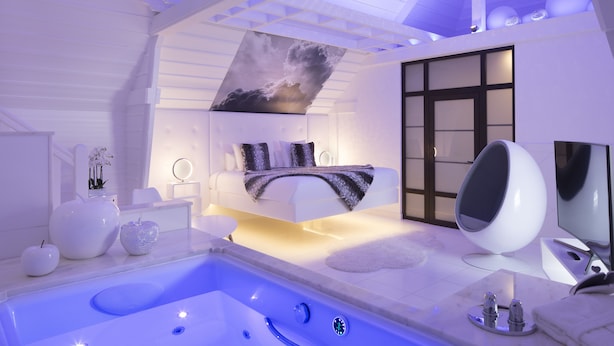 A modern bathroom with a large bathtub, a seating area with a sofa, and a large mirror. - Hôtel et Spa Le Lion d'Or (Pont-l'Eveque)
