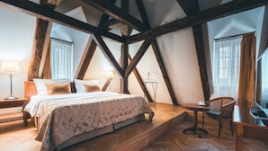 A bedroom with a bed, bedside tables, a chair, and a desk. - Appia Hotel Residences (Prague)