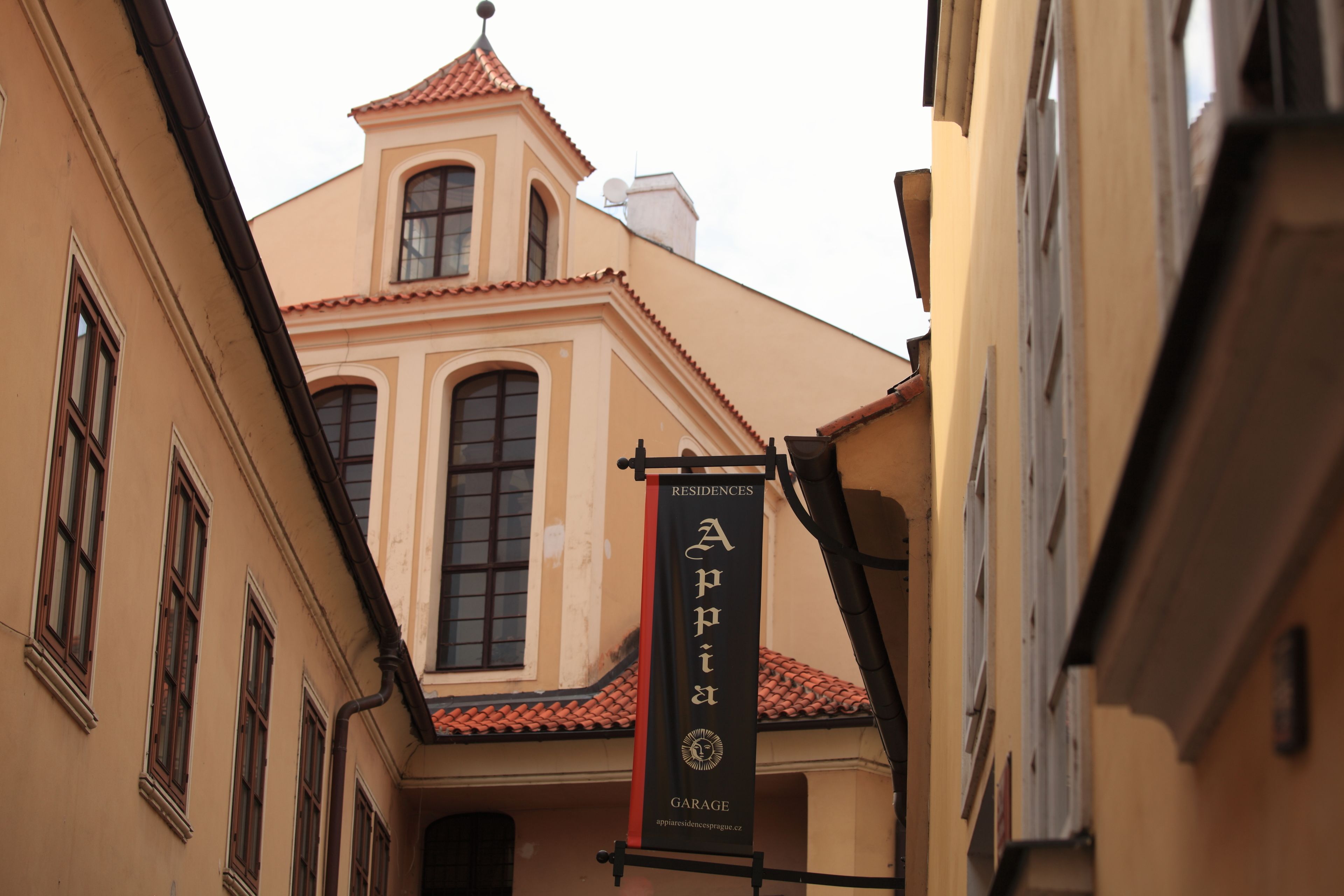 A building with a red-tiled roof and a banner advertising a residence.