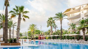 En sÀsongsöppen utomhuspool, parasoller och solstolar