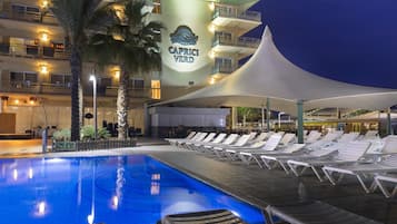 En sÀsongsöppen utomhuspool, parasoller och solstolar