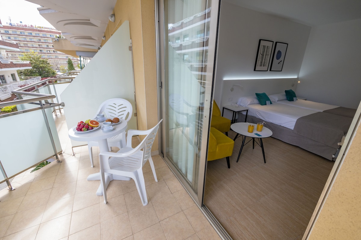 A balcony with a table, chairs, and a breakfast setup.