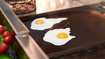 Two sunny-side-up eggs on a hot griddle.