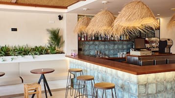 Un espace bar avec des tabourets, un comptoir et un plafond décoratif.