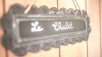 A decorative sign with the text "Le Chalet" in a rustic, carved frame.