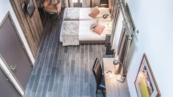 A bedroom with a bed, bedside tables, a desk, and a chair. There is a staircase leading to another level.