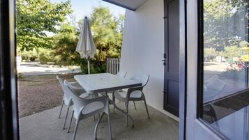 A patio with a table and chairs, a door, and a view of the outdoors.