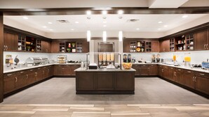 Una cocina moderna con armarios de madera oscura, una isla central y varios electrodomésticos.