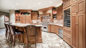 Una cocina con armarios de madera, encimera de granito y horno empotrado.