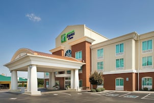 Um Holiday Inn Express & Suites com área de estacionamento coberta e fachada de tijolos.