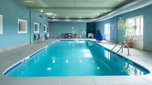 An indoor swimming pool with clear blue water, surrounded by walls painted in a light blue color. There are several windows allowing natural light to enter the room. - Holiday Inn Express & Suites Lenoir Cty by IHG (Lenoir City)