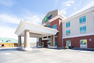 Un Holiday Inn Express & Suites con un espacio exterior cubierto y estacionamiento.