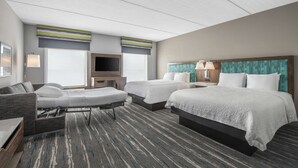 A hotel room with two beds, a sofa, a TV, and a desk. - Hampton Inn & Suites-Dallas Allen (Allen)