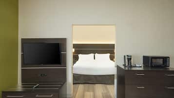 A hotel room with a bed, a television, a coffee maker, and a microwave.