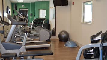 Een sportschool met loopbanden, elliptische trainers en losse gewichten.