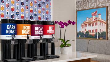 A coffee station with four dispensers labeled DARK ROAST, LIGHT ROAST, DECAF ROAST, and HOT WATER.